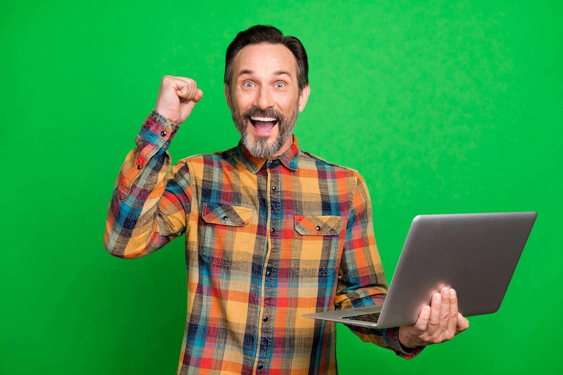 Blije man met laptop Zo vind je de perfecte laptop